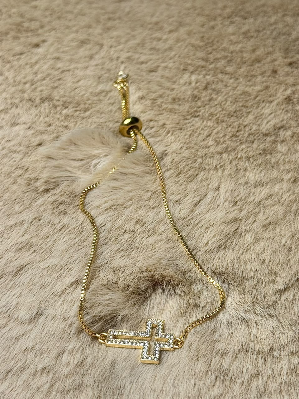 Pulsera ajustable con dije de cruz dorado