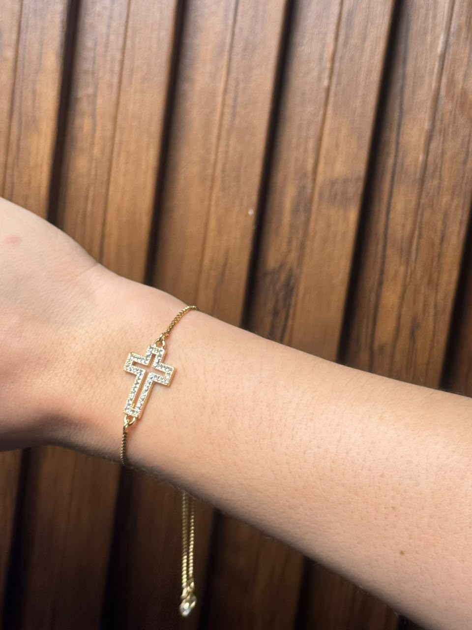 Pulsera ajustable con dije de cruz dorado