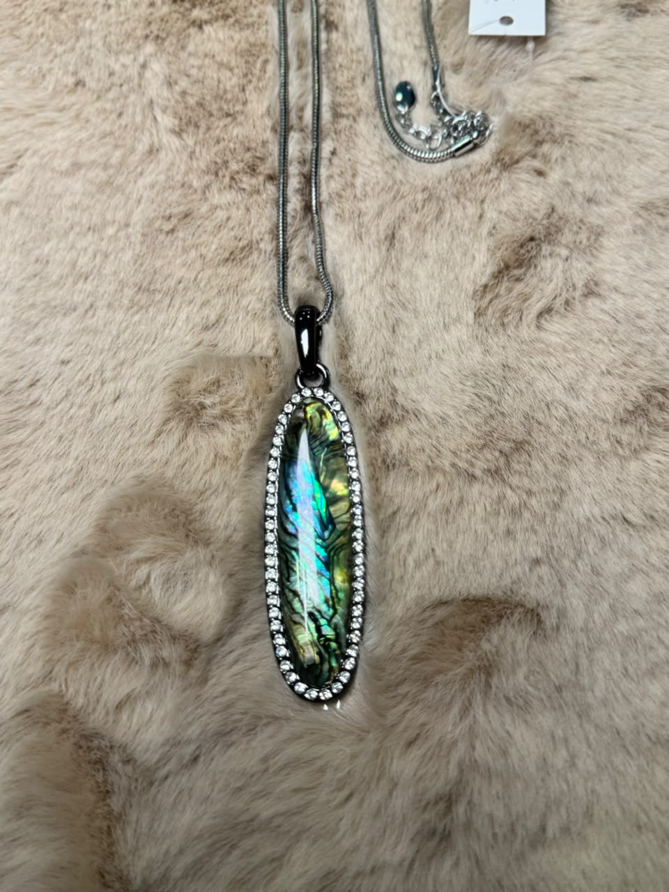 Collar largo de cadena plateada con dije ovalado de concha abulón